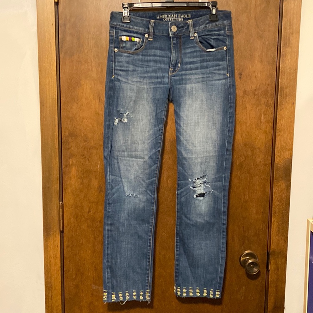 AMERICAN EAGLE distressed medium washed denim jeans. Cute home-done embroidery.